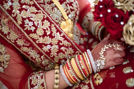 Gold and red embroidered asian wedding dress with gold bangles and jewellery