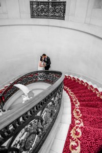 Bride and groom on their wedding day posing on the spiral staircase inside the Luton Hoo Hotel